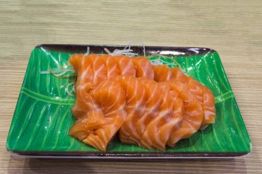 Somon balığı yeşil bir tabak üzerinde.