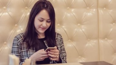 Güzel kız ile belgili tanımlık telefon. App akıllı kafede kullanan kadın. Manifatura üstünde hareket eden telefon.