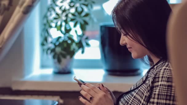 Mooi meisje met de telefoon. Vrouw met behulp van de app op smartphone in café. SMS op mobiele telefoon. — Stockvideo