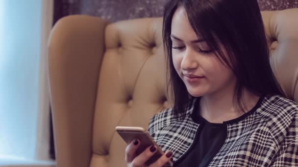 Schöne Mädchen mit dem Telefon. Frau nutzt App auf Smartphone im Café SMS auf dem Handy. — Stockvideo