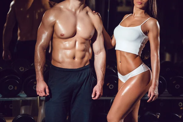 Sport meisje en man in de sportschool. Wit overhemd. Gelooid. Sexy. — Stockfoto