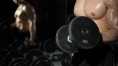 Adam jimnastik salonu. Egzersizleri dumbbells ile mu.