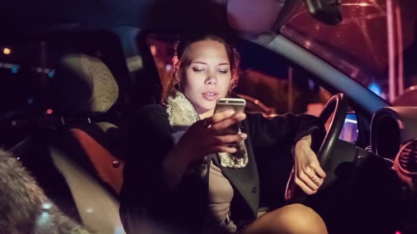 Vacker flicka med en telefon i bilen — Stockvideo