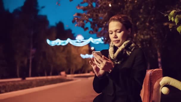 Vacker flicka med en telefon på gatan — Stockvideo