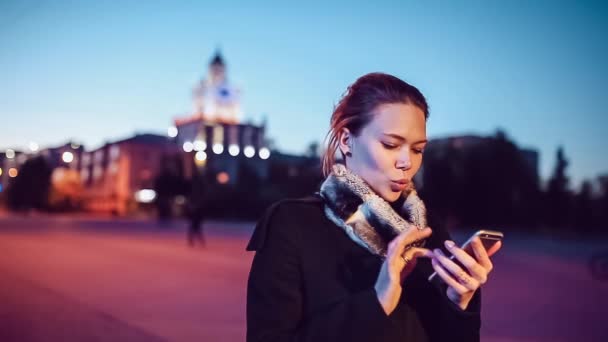 Mooi meisje met een telefoon op straat — Stockvideo