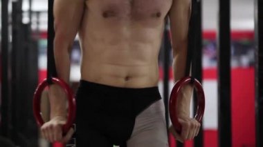 Yüzüklerin üzerinde yapıyor atlet. Yakın çekim.