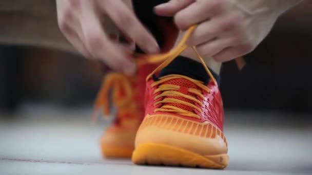 L'atleta che lega lacci di scarpe da ginnastica. Preparazione per l'esercizio. Primo piano . — Video Stock