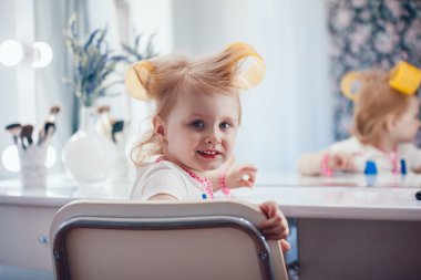 Onun makyaj aynası önünde küçük kız