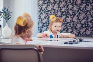 Onun makyaj aynası önünde küçük kız