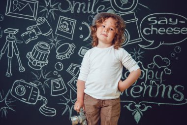 Bir kamera ile küçük çocuk sözlerle siyah bir arka plan üzerinde duruyor