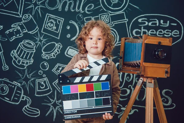 Malý chlapec stojící u fotoaparátu na černém pozadí se slovy — Stock fotografie