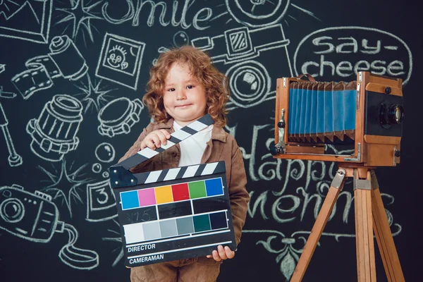 Niño pequeño de pie cerca de la cámara sobre un fondo negro con las palabras —  Fotos de Stock