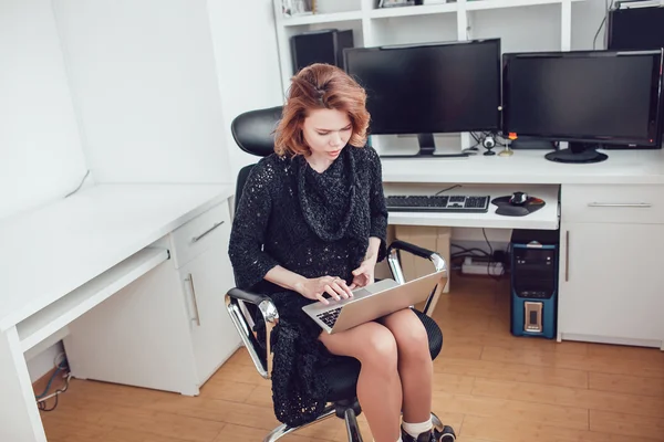 Jonge zakenvrouw met een computer in het kantoor — Stockfoto