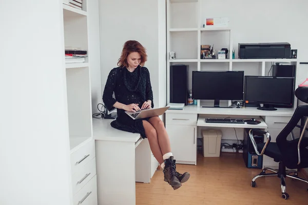 Jonge zakenvrouw met een computer in het kantoor — Stockfoto