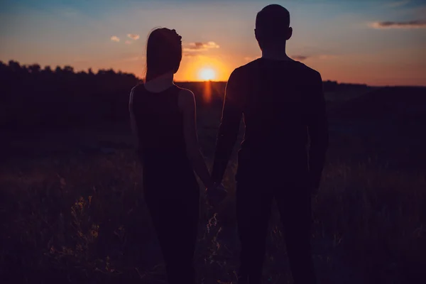 Het verhaal van de liefde. Paar bij zonsondergang. Op de achtergrond van de hemel. Wolken. — Stockfoto