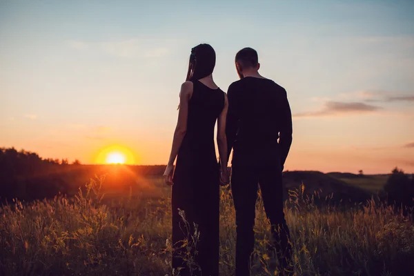 Liebesgeschichte. Paar bei Sonnenuntergang. auf dem Hintergrund des Himmels. Wolken. — Stockfoto