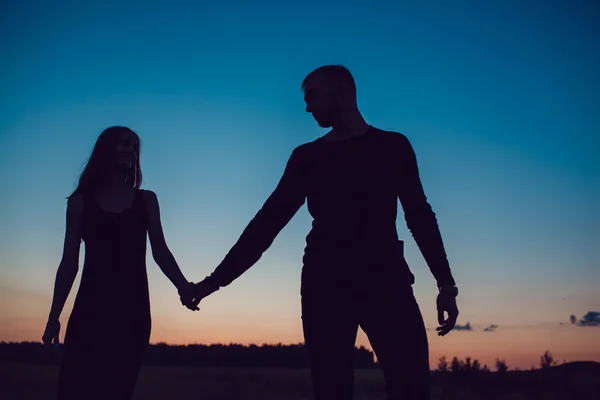 Het verhaal van de liefde. Paar bij zonsondergang. Op de achtergrond van de hemel. Wolken. — Stockfoto