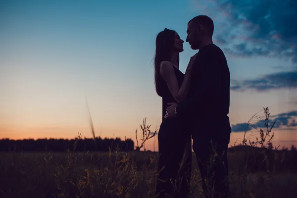 História de amor. Casal ao pôr-do-sol. No fundo do céu. Nuvens . — Fotografia de Stock