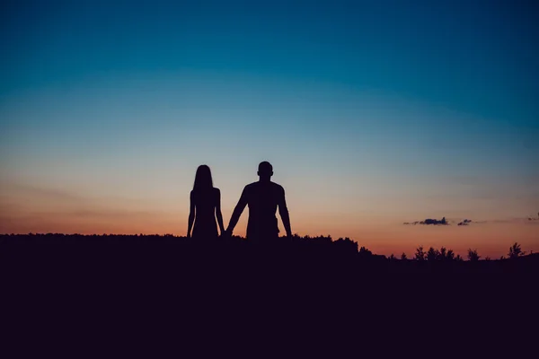 Historia de amor. Pareja al atardecer. En el fondo del cielo. Nubes . — Foto de Stock