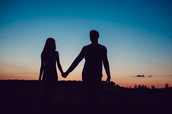 Historia de amor. Pareja al atardecer. En el fondo del cielo. Nubes . — Foto de Stock