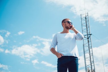 Çatı telefonda konuşan adam. Mobil anten. Gökyüzü.