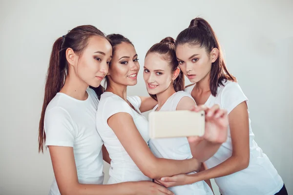 Positive friends portrait of four happy girls making selfie, sure funny faces, grimaces, joy, emotions, casual style, pastel colors, white wall. crazy funny woman. White background. — Stock Photo, Image