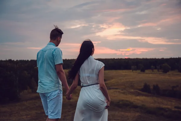 Het verhaal van de liefde. In liefde paar lopen op zonsondergang achtergrond. Silhouet cijfers van mensen verliefd op de natuur. Screensaver voor de film. — Stockfoto