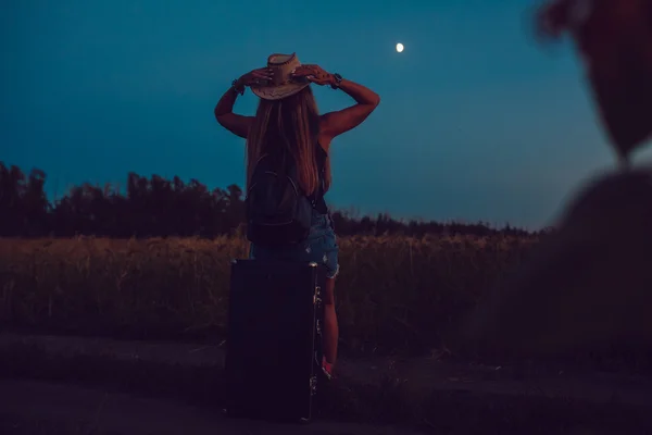 Ze verloor in de zonnebloem veld zit op een koffer. Wachten op hulp. Nacht. — Stockfoto