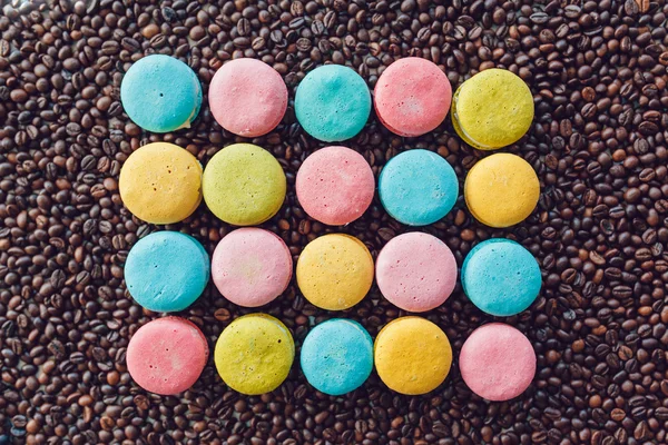 Édes és színes francia macaroons kávébab háttér — Stock Fotó