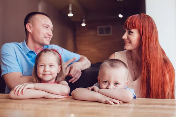 Lycklig familj väntar på beslutet i en restaurang — Stockfoto