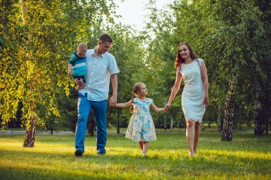Mutlu genç aile yürüyüş ve having fun parkta Dört Kişilik