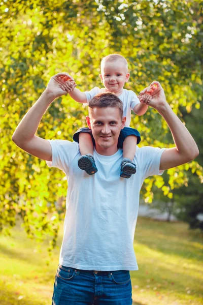 Pappa håller sin son på axlar i park — Stockfoto