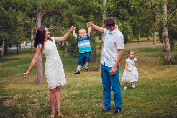 Молодая семья из четырех человек веселится в парке — стоковое фото