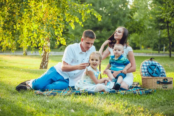 Jeune famille heureuse de quatre personnes en pique-nique dans le parc — Photo