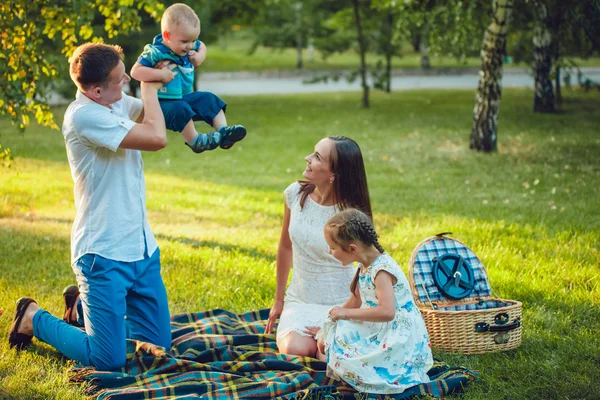 Jeune famille heureuse de quatre personnes en pique-nique dans le parc — Photo