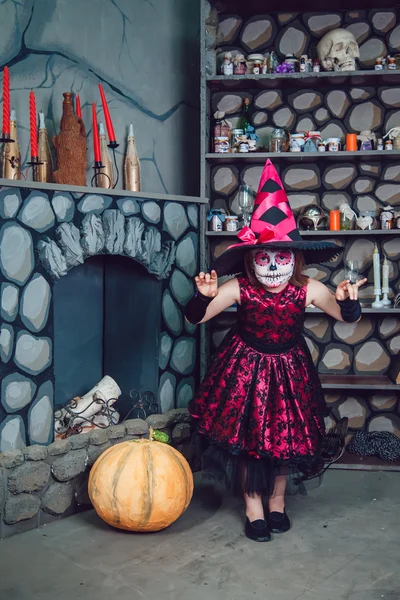 Chica en traje de bruja y maquillaje en su cara de pie en decoraciones de Halloween — Foto de Stock