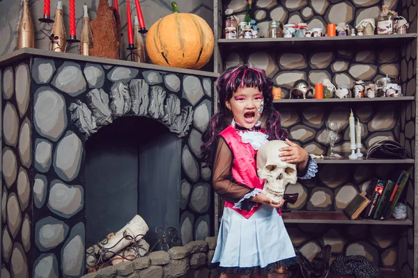 Девушка в костюме ведьмы череп в его руке в пейзаже Хеллоуин — стоковое фото