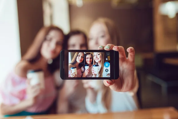 Three young girls are doing selfie in fast food restaurant — Stock Photo, Image