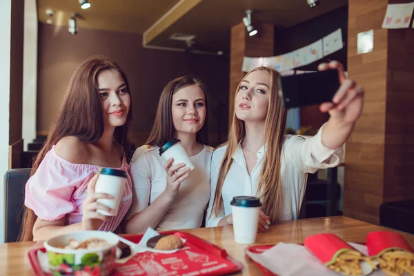 Trzy młode dziewczyny robią selfie w restauracji fast food — Zdjęcie stockowe