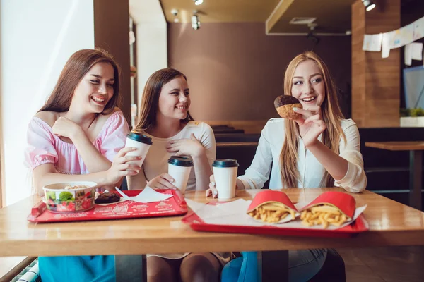 レストランにファーストフードを食べる 3 つの陽気な若い女の子 — ストック写真