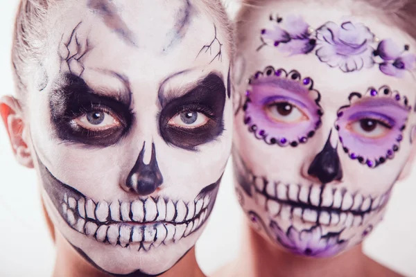 Dos chicas con el arte de la cara de Halloween sobre fondo blanco — Foto de Stock