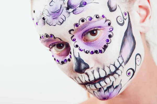 Chica con Halloween arte de la cara sobre fondo blanco — Foto de Stock