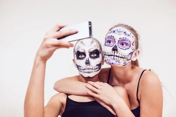 Две девушки идут на Хэллоуин, гримаса и сделать селфи — стоковое фото