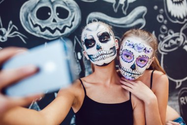 İki kız Cadılar Bayramı'nda, gidiş Face ve selfie yapmak