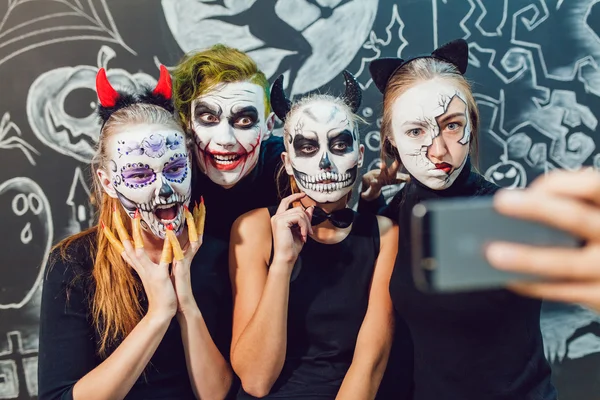 Üç kız ve bir adamın Cadılar Bayramı'nda çıktığını, yüz buruşturma yapmak selfie