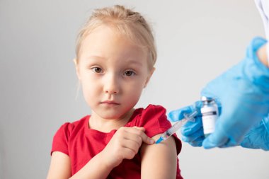 Doktor çocuğa kovid 19 aşısı enjekte ediyor..