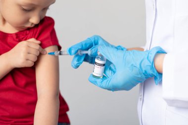 Doktor çocuğa kovid 19 aşısı enjekte ediyor..