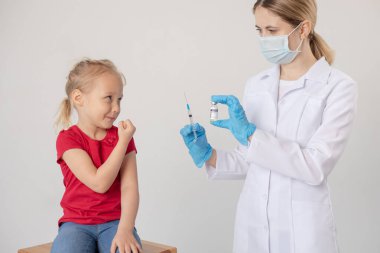 Bir çocuk elinde şırınga ve kovid aşısı olan bir doktora karşı kendini savunur..