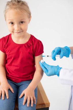 Doktor çocuğa aşıyı enjekte ediyor..