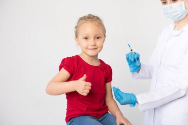 Woman doctor with a syringe and child showing thumb up. clipart